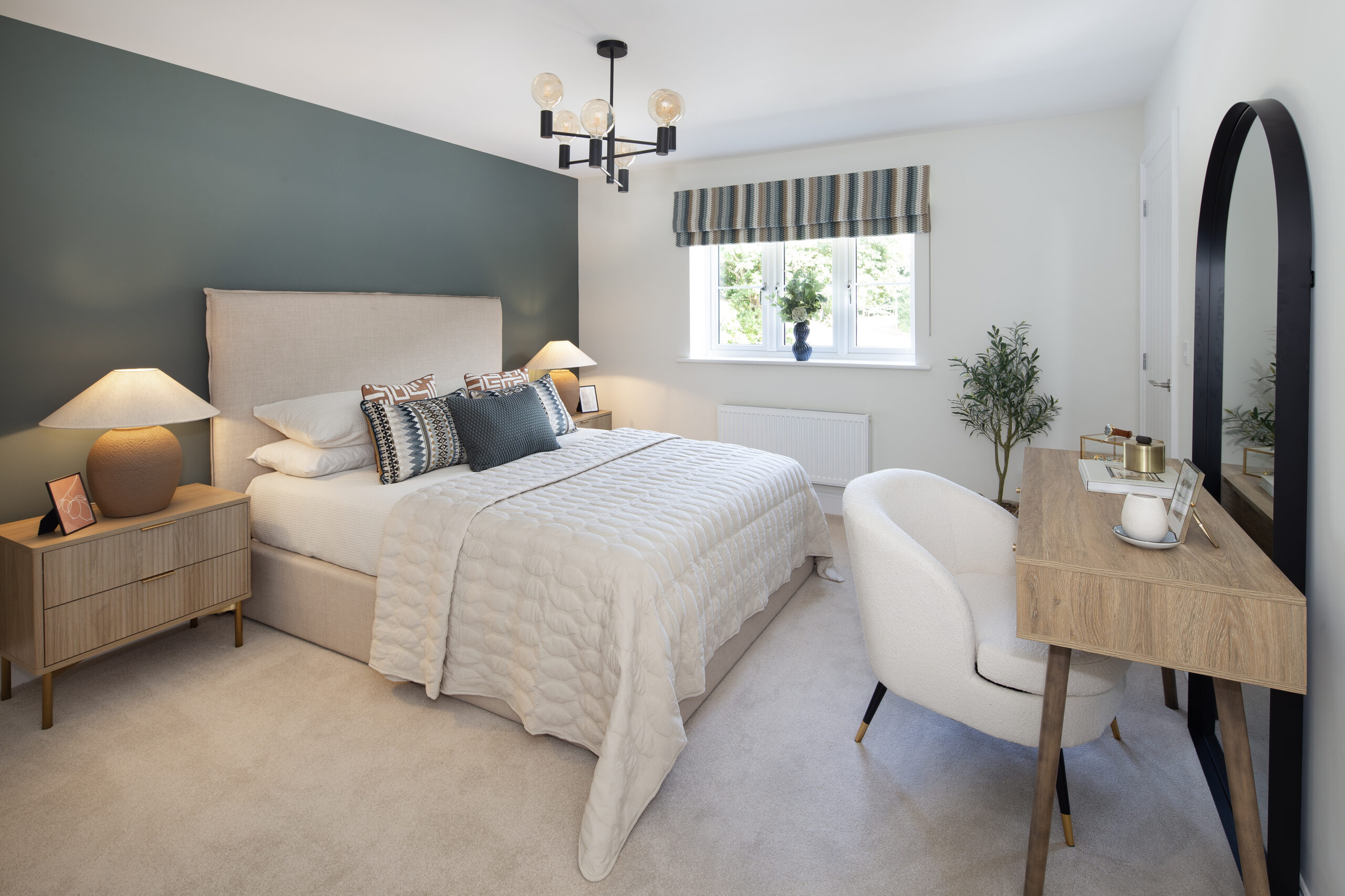 Guest bedroom with strong blue feature wall and touches of blues and ochre in the roman blinds and cushions