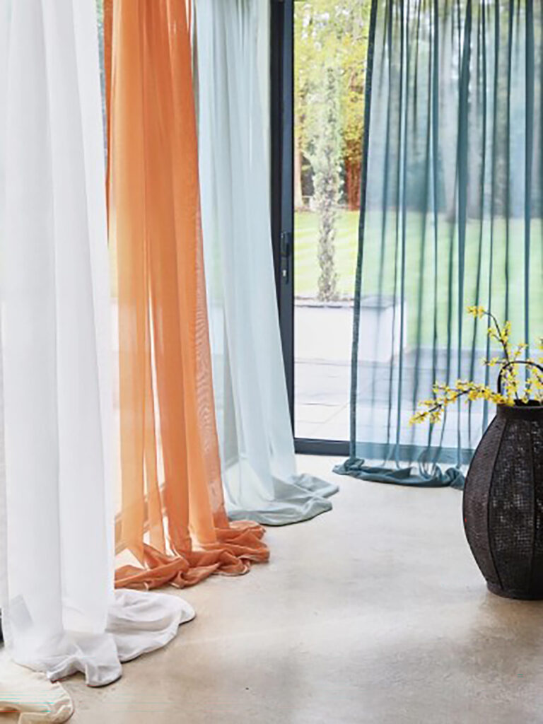 Sheer curtains in soft pastel colours.